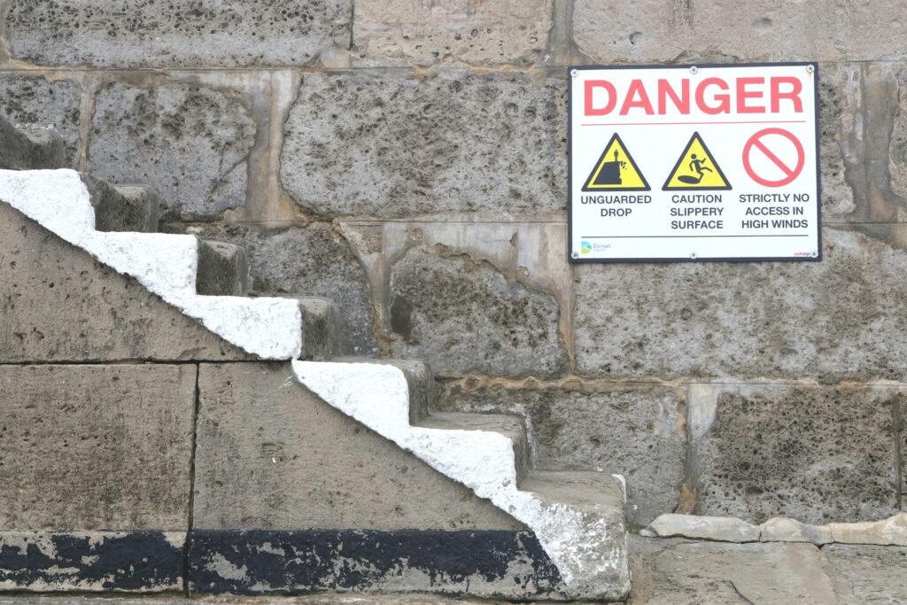 a sign on a stone wall warning of danger